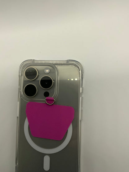 Be My AI: The picture shows a clear phone case on a smartphone. The smartphone appears to be an iPhone with a square camera module in the top left corner that has three lenses and a flash. The phone case has a pink adhesive card holder attached to the back. The card holder is in the shape of a small pocket and has a ring at the top, which can probably be used to hold or secure the phone. The background is plain and white.