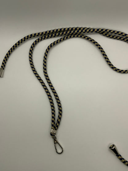 Be My AI: The picture shows a lanyard. The lanyard is made of a fabric that has a zigzag pattern with black and yellow colors. It is lying on a plain white surface. One end of the lanyard has a metal clasp attached to it, which is silver in color. The other end of the lanyard is not fully visible in the picture, but it appears to have a small metal piece attached to it. The lanyard is curved in a wavy manner on the surface.