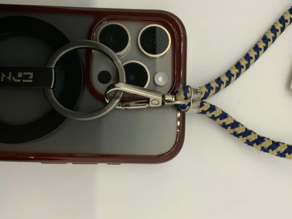 Be My AI: The picture shows a close-up of a few objects. There is a smartphone with a red case. The case has a cut-out on the back revealing the phone's camera lenses and flash. 

There is also a black ring attached to the back of the phone case, possibly for grip or as a stand. The word "ENJ" is visible on the black ring.

Additionally, there is a metal carabiner clip attached to the black ring. The carabiner is connected to a braided lanyard that is blue and beige in color.

The background is a plain whit