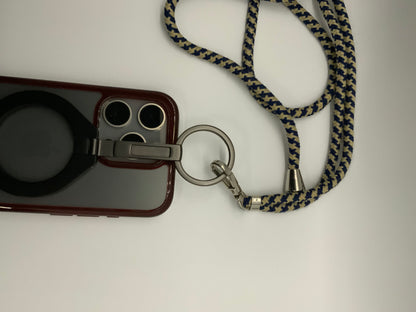 Be My AI: The picture shows a phone case with a strap. The phone case is a deep red color and has a circular cutout on the back, possibly for a logo. There are also three circular cutouts at the top left corner of the case, likely for the camera lenses. Attached to the case is a metal ring with a strap. The strap is made of fabric and has a zigzag pattern in dark blue and beige colors. The strap is looped and appears to be long enough to wear around the neck. There is also a small metal bell attached to the