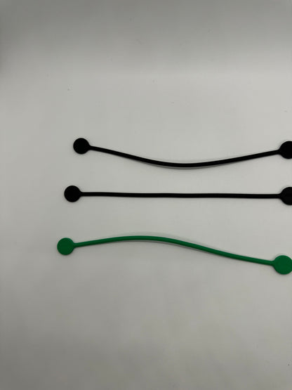 The picture shows three cable ties on a white background. Two of them are black and one is green. The cable ties are thin, flexible bands with a small disc at one end. They are arranged in a parallel fashion with the green one at the bottom. The black cable ties are slightly curved, while the green one has a more pronounced curve.