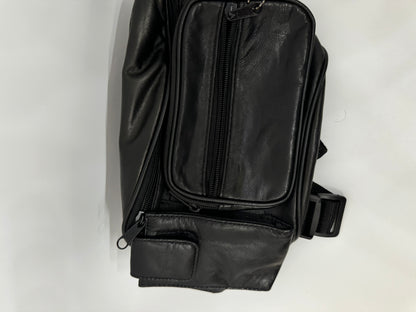 The picture shows a black leather bag. It appears to be a small bag, possibly a waist bag or a small sling bag. The bag has a vertical zipper on the front and seems to have a pocket behind it. There is also a black strap with a plastic buckle visible, which is likely used to secure the bag around the waist or across the body. The background is plain white.