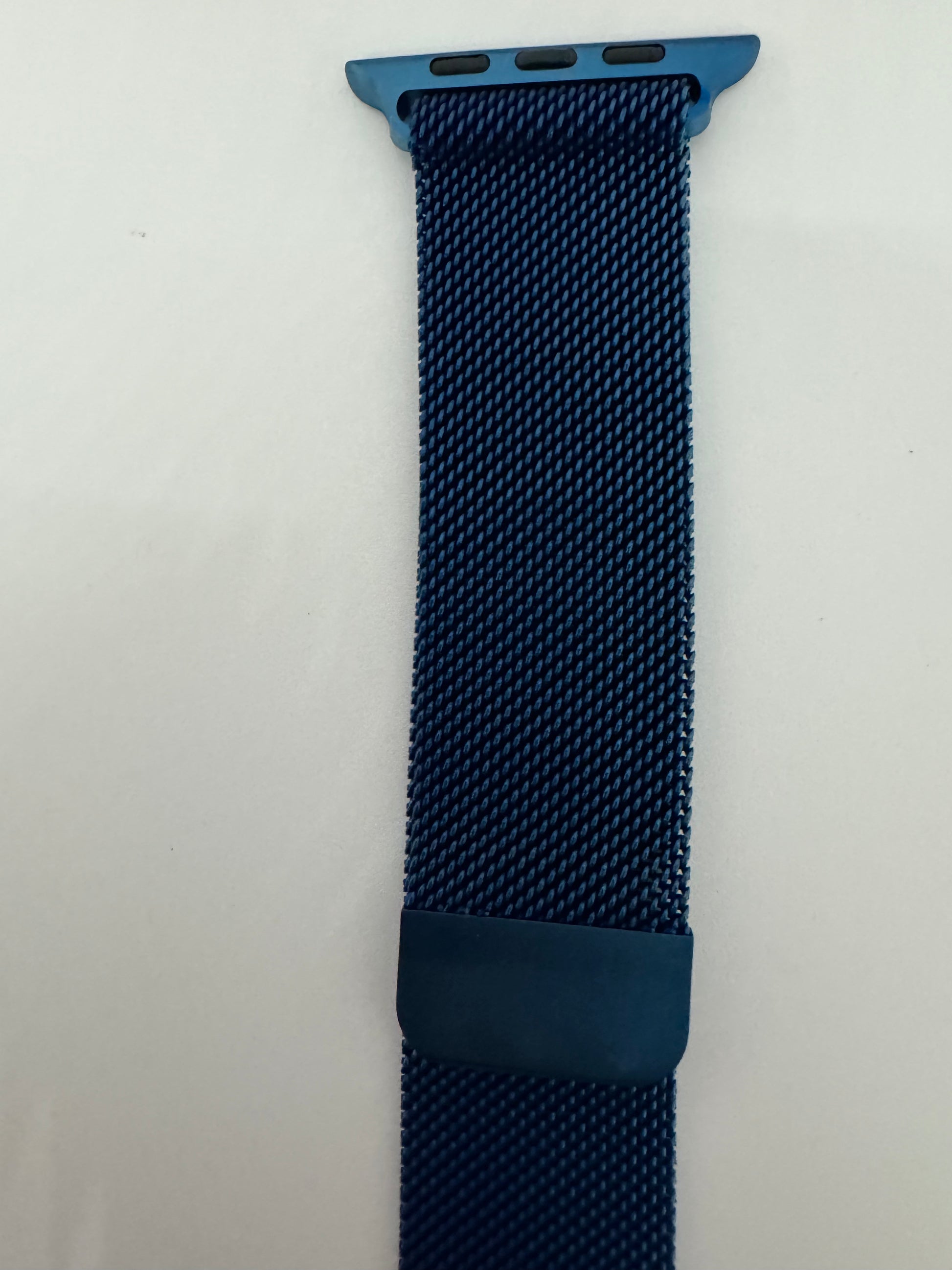 The picture shows a watch band. It is a woven band with a deep blue color. The texture appears to be a tight mesh pattern. At the top, there is a metallic attachment with a similar blue color that has three holes, presumably to attach it to a watch. At the bottom, there is a darker blue loop that is likely used to secure the end of the band. The background is plain white.