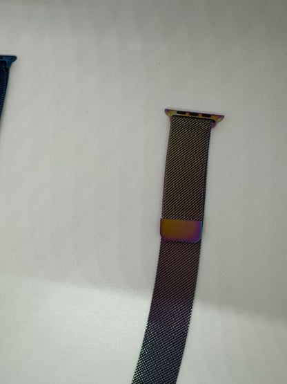 Be My AI: The picture shows a part of two watch bands on a white background. The one on the right is more visible and appears to be a metallic mesh band. The top part of the band has a metallic clip with holes, possibly for attaching it to a watch. The band has a dark color, and the clip has a slight iridescent hue with colors like purple and gold. The band on the left is partially visible with a similar mesh texture but in a dark blue color.
