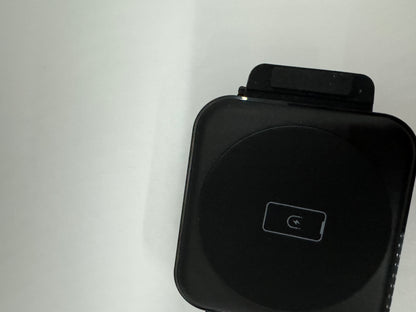 Be My AI: The picture shows a black object against a white background. The object appears to be a square-shaped device with rounded corners. On the top of the device, there is a smaller rectangular attachment. The front of the device has a circular indentation with a symbol inside, which looks like a phone icon indicating a call. The device seems to be made of a glossy material.