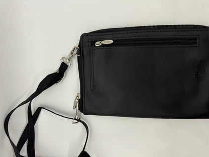 The picture shows a black pouch or small bag. It has a zipper on the top with a silver zipper pull. The pouch appears to be made of a smooth material, possibly leather. There is an emblem embossed on the lower right corner of the pouch, but it's not clear what the emblem is. Attached to the pouch is a black strap with silver clasps. The strap is made of a fabric material and is attached to the pouch by silver metal hooks. The background is plain white.